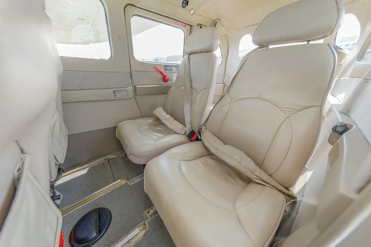 Interior of a light aircraft with beige leather seats and side windows