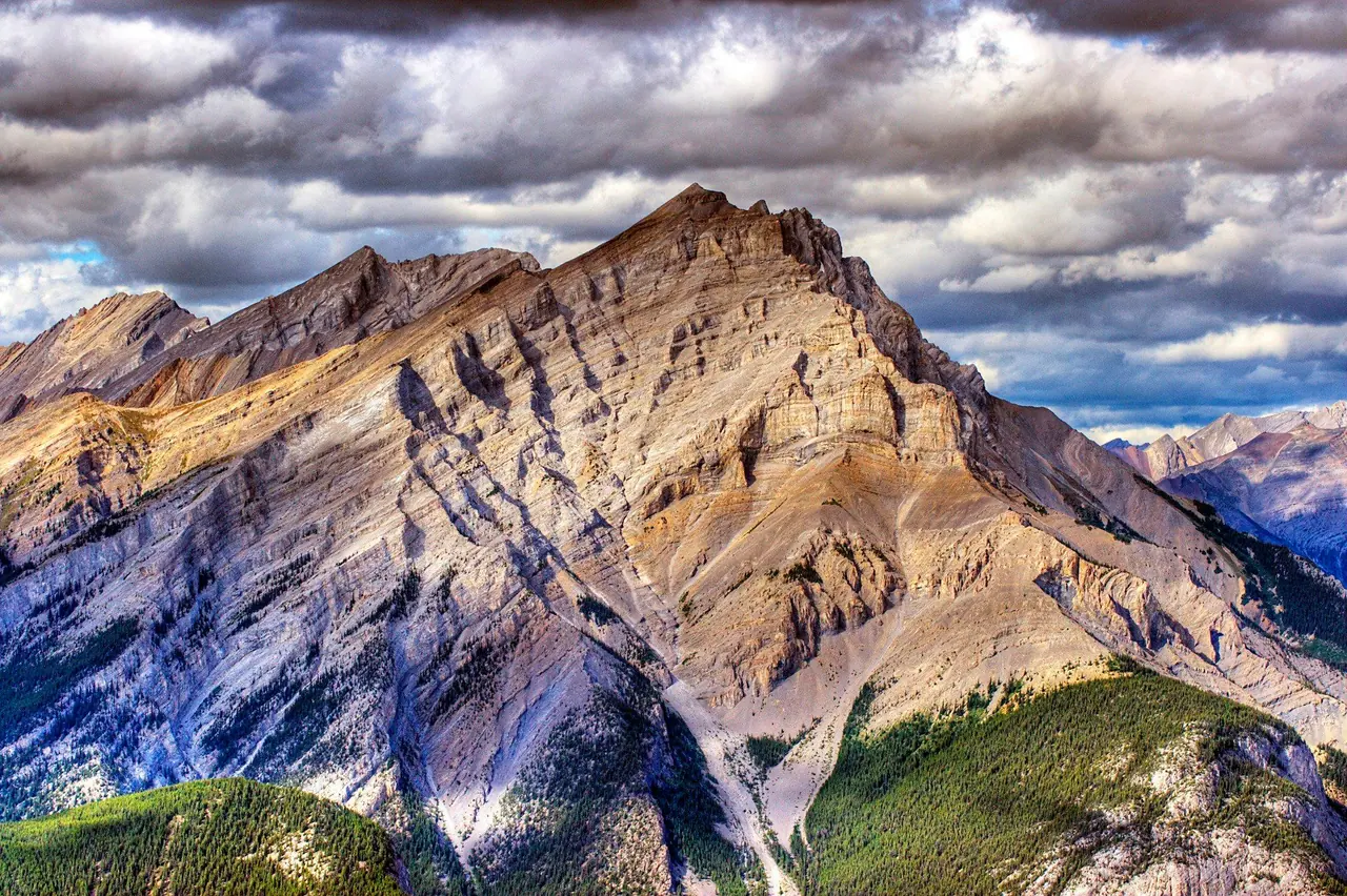 Rocky Mountain peaks under a dramatic cloudy sky near Banff, Alberta