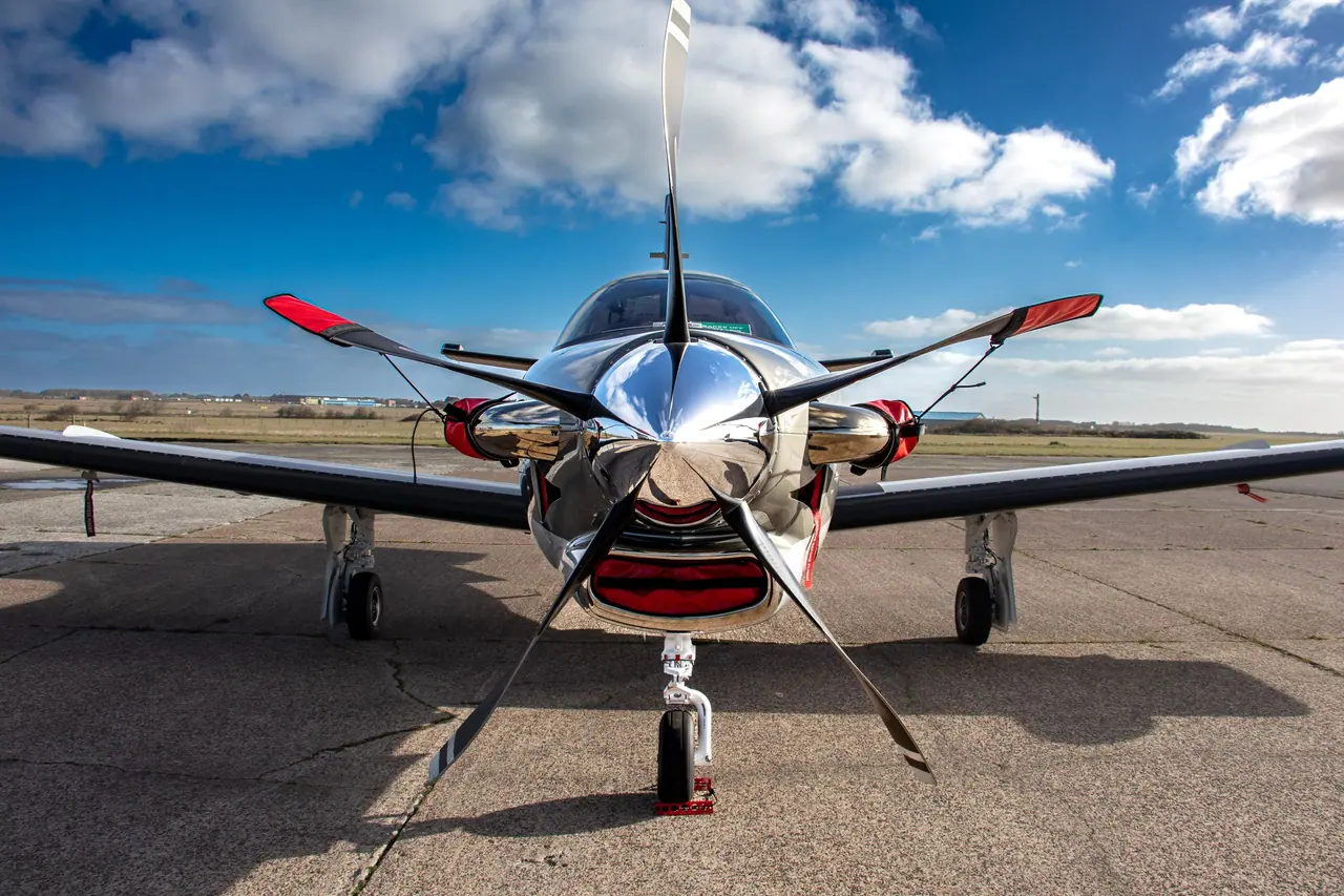 Mirror-polished propeller spinner reflecting the sky on a parked turboprop